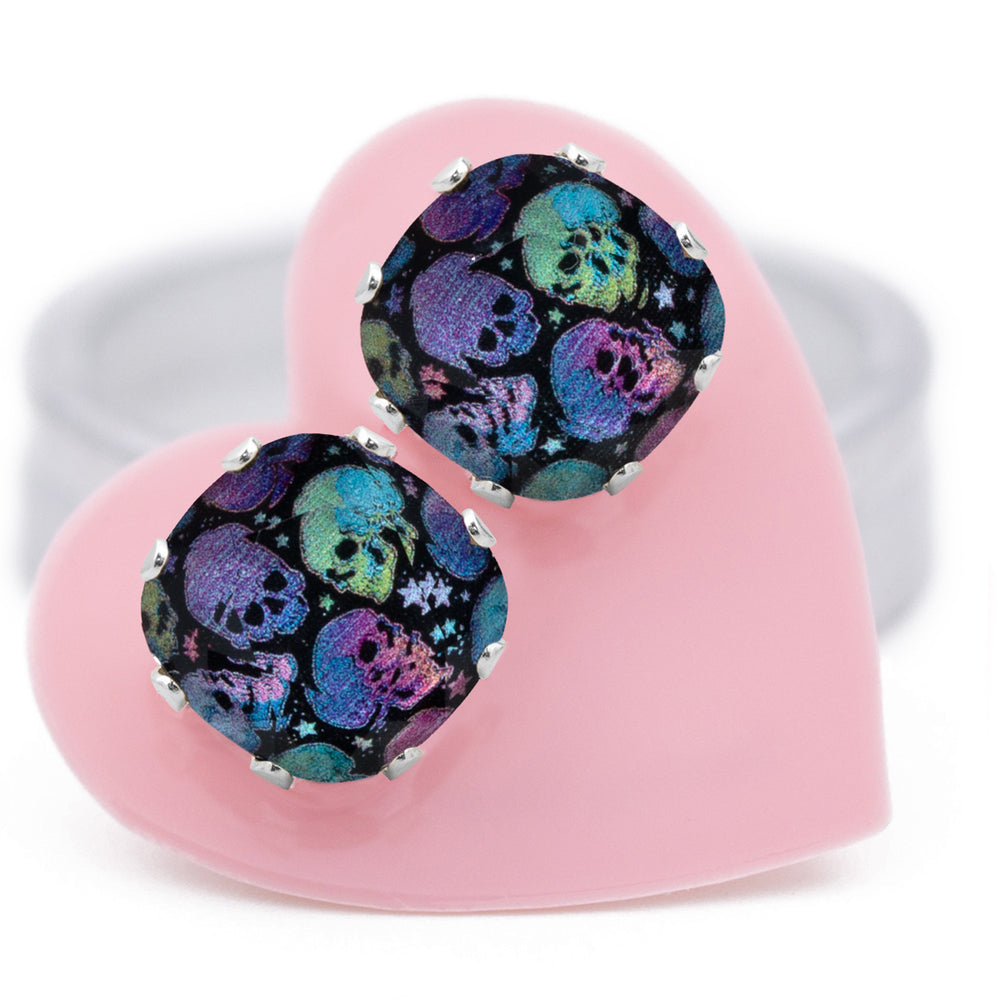 Deadly Disco Cushion stud earrings with a bold, colorful skull design, set in .925 Sterling Silver, carded on a pink heart.